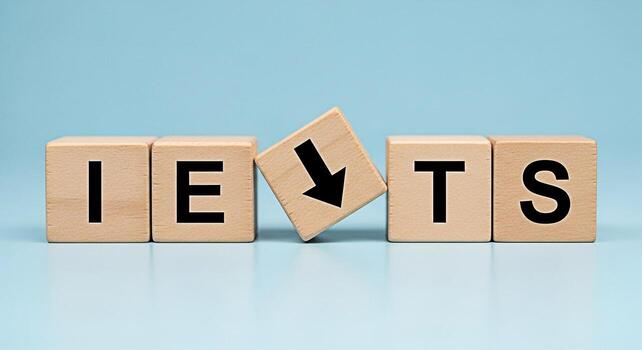 IELTS letters displayed on wooden blocks with a falling arrow block on a blue background symbolizing a drop in IELTS scores creating a sense of challenge and the need for improvement in English profic photo