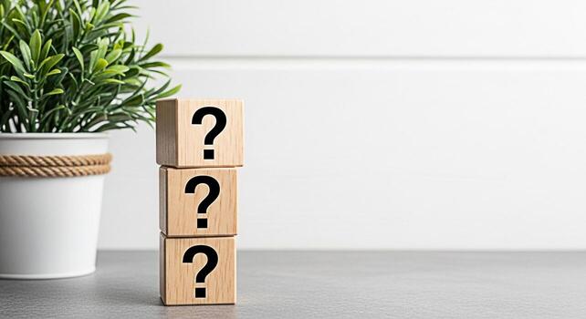 Stacked wooden blocks displaying question marks on a gray surface in a bright room representing uncertainty problemsolving and the search for answers in business education and personal development photo