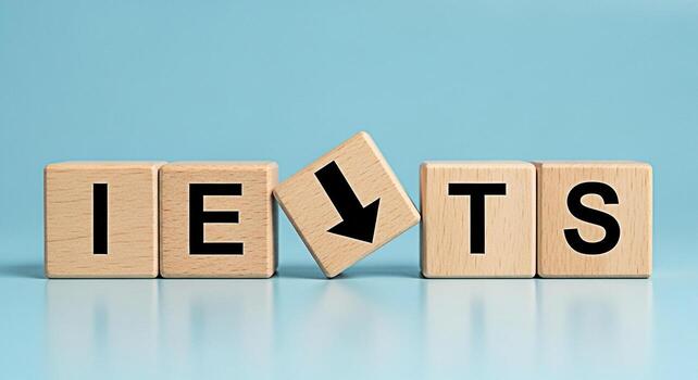 Wooden blocks spelling IELTS with a falling arrow block on a blue background symbolizing challenges and difficulty in the International English Language Testing System exam preparation photo