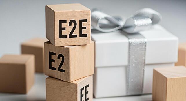 Wooden blocks displaying E2E in a bright studio setting symbolizing endtoend solutions and business efficiency with a gift box in the background evoking a sense of achievement and successful outcomes photo