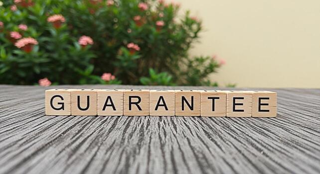 Wooden blocks spelling GUARANTEE on a textured surface with a vibrant floral background conveying assurance and reliability in a natural calming setting symbolizing trust and commitment photo