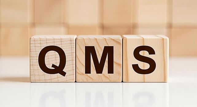 Wooden blocks displaying QMS on a white surface representing Quality Management System in a business setting emphasizing precision control and systematic approach to quality assurance and operational photo
