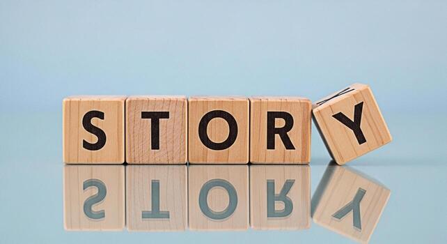 Wooden blocks spelling STORY on a reflective surface against a light blue background conveying a sense of narrative imagination and the power of storytelling in a simple clean and visually appealing c photo
