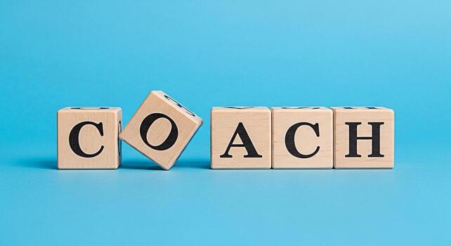 Wooden blocks spelling COACH on a blue background symbolizing guidance and mentorship conveying a message of support and development creating a positive and encouraging atmosphere for personal and pro photo