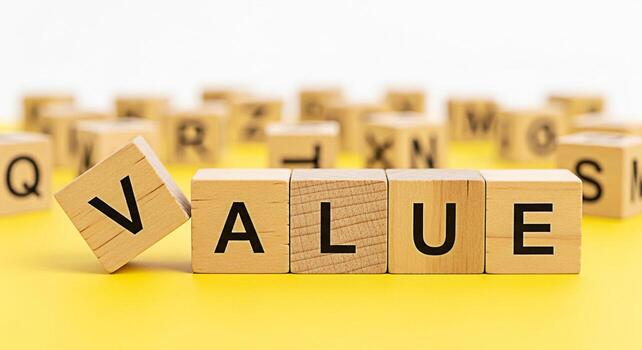 Wooden blocks spelling VALUE on a bright yellow surface symbolizing importance and worth conveying a message of quality integrity and the significance of ethical principles in business and life photo