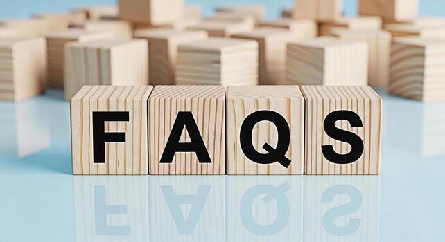 Wooden blocks spelling out FAQs on a reflective surface surrounded by other blocks representing frequently asked questions and information resources in a clear and accessible manner photo