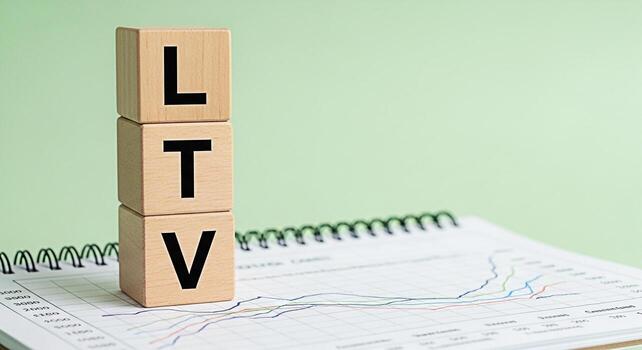 Wooden blocks spelling LTV stacked on a notebook with a line graph representing customer lifetime value in a business setting symbolizing growth and financial planning on a light green background photo