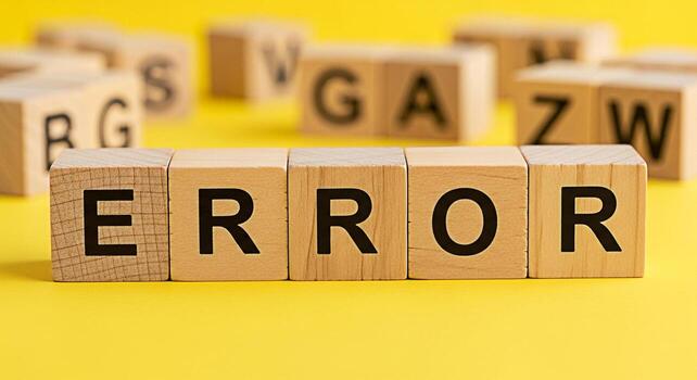 Wooden blocks spelling ERROR on a bright yellow surface surrounded by other letter blocks symbolizing a system failure a problem or a mistake in a playful and educational environment photo