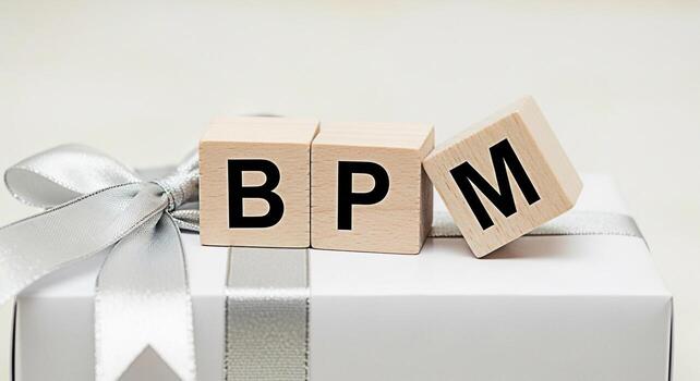 de madera bloques ortografía bpm descansando en un pulcramente envuelto regalo caja con un plata cinta simbolizando negocio proceso administración y eficiencia creando un estado animico de organización y estratégico planificación foto