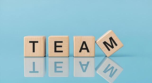 Wooden blocks spelling TEAM on a reflective blue surface symbolizing collaboration and teamwork fostering a positive and supportive environment for achieving common goals and building strong relations photo