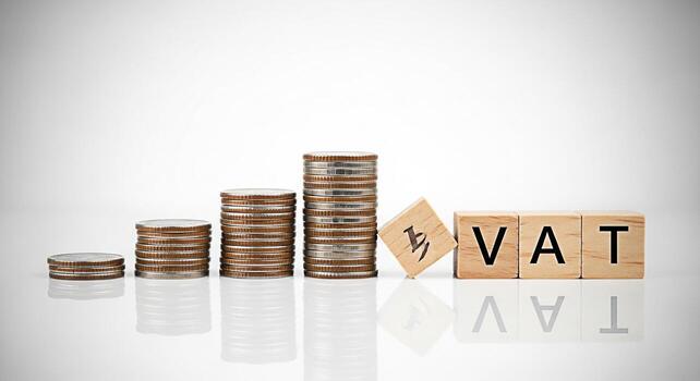 pilas de monedas creciente siguiente a de madera bloques ortografía IVA en un blanco superficie representando valor adicional impuesto y financiero crecimiento en un limpiar minimalista estudio ajuste transporte un sentido de estabilidad y pags foto