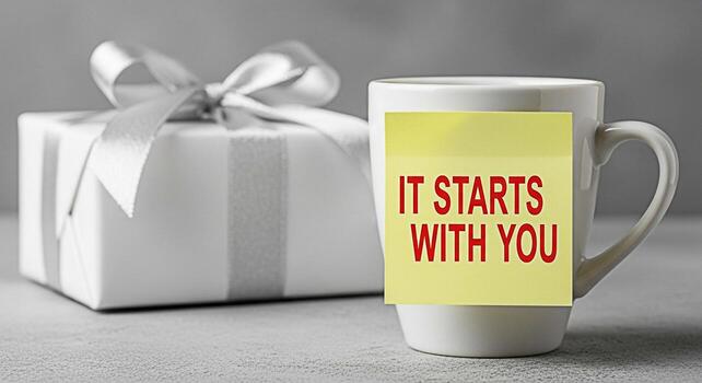 Gift box and mug with a motivational message on a gray surface symbolizing personal growth and positive affirmation in a minimalist setting inspiring selfimprovement and a proactive mindset for succes photo