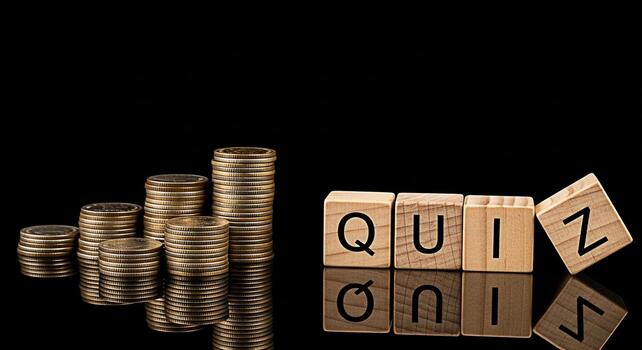 Stacks of coins increasing next to wooden blocks spelling QUIZ on a reflective black surface representing financial literacy and the importance of knowledge in achieving monetary success photo