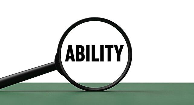 Magnifying glass focusing on the word Ability on a green surface symbolizing skill assessment and potential highlighting the concept of capability and competence in a professional setting photo