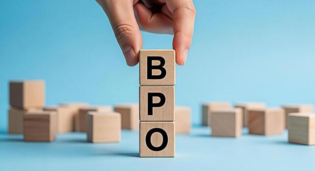 Hand arranging wooden blocks spelling BPO on a blue background symbolizing business process outsourcing and efficient business solutions creating a professional and trustworthy atmosphere photo