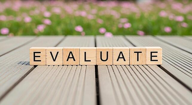 Wooden blocks spelling EVALUATE on a wooden surface in a garden setting symbolizing assessment analysis and the importance of critical thinking for informed decisionmaking and continuous improvement photo