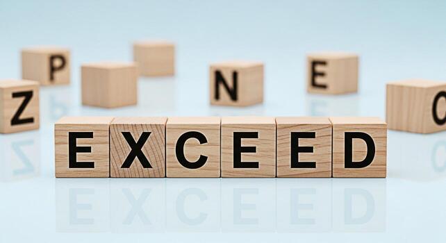 Wooden blocks spelling EXCEED on a reflective surface surrounded by scattered letter blocks symbolizing ambition and the drive to surpass expectations in a bright minimalist setting conveying a messag photo