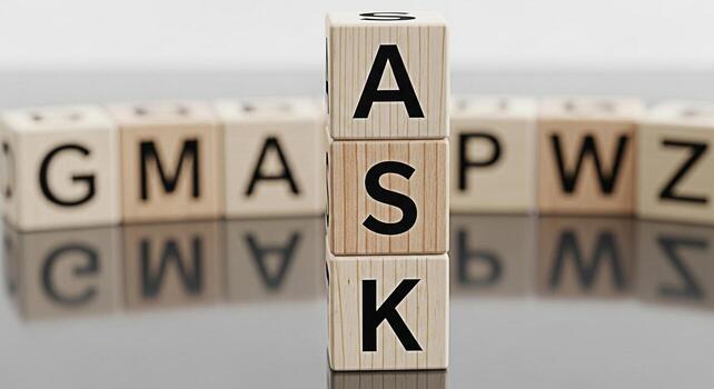 Wooden blocks spelling ASK stand prominently on a reflective surface surrounded by blurred alphabet blocks creating a sense of curiosity and encouraging questions in a learning environment photo