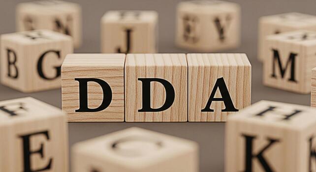 Wooden blocks spelling DDA on a neutral surface surrounded by other lettered blocks representing data driven approach data analysis and digital accessibility conveying a sense of learning and developm photo