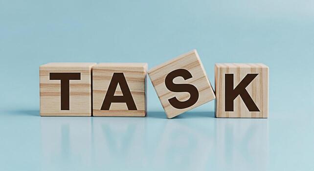 Wooden blocks spelling out TASK on a light blue surface symbolizing project management and workload conveying a sense of organization and focus in a minimalist clean environment photo