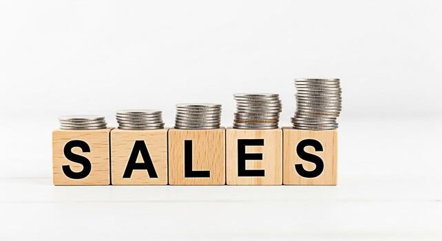 Stacking coins on wooden blocks spelling SALES on a white background representing growth and financial success symbolizing positive business trends and increasing revenue conveying a message of prospe photo