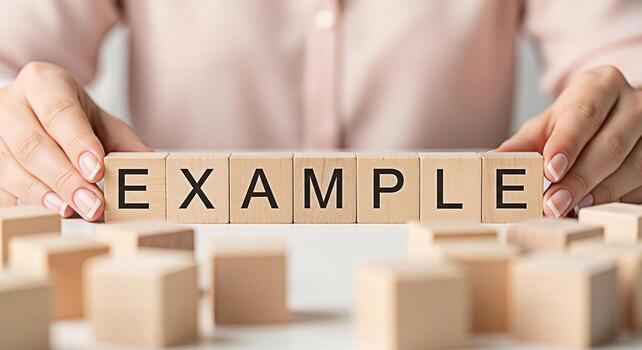 Womans hands arranging wooden blocks spelling EXAMPLE on a white surface demonstrating a concept with clarity and precision ideal for educational materials and business presentations photo