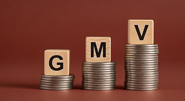 Wooden blocks displaying GMV letters sitting atop stacks of coins against a solid brown background representing Gross Merchandise Value and business growth in a financial and investment context photo