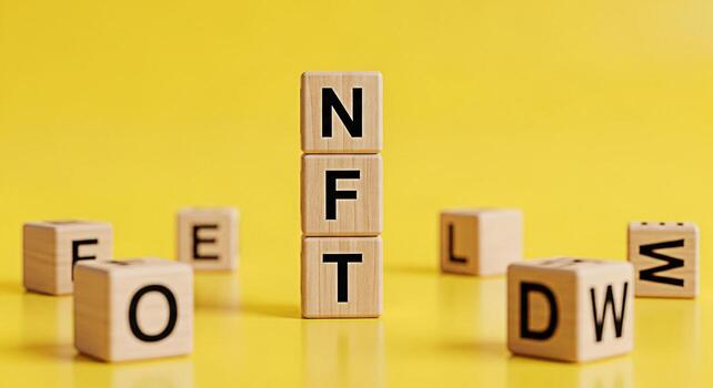 Wooden blocks spelling NFT on a bright yellow background representing the concept of nonfungible tokens and digital assets conveying a sense of innovation and the future of cryptocurrency and blockcha photo