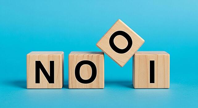 Wooden blocks spelling NOI on a blue surface with one block slightly tilted conveying a sense of incompleteness and the need for further action ideal for concepts related to decisionmaking and problem photo