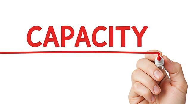 Hand underlining the word Capacity in red marker on a white background symbolizing potential ability and the power to achieve goals representing business growth and personal development photo