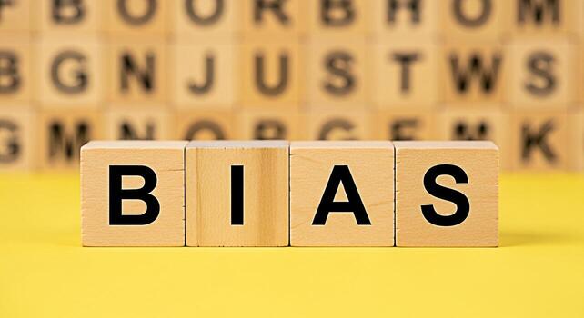 Wooden blocks spelling BIAS on a yellow surface representing prejudice and unfairness in a bright minimalist setting highlighting the importance of objectivity and critical thinking in decisionmaking photo