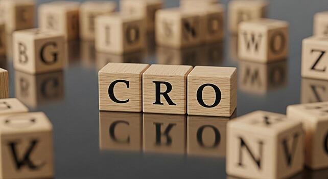 Wooden blocks spelling CRO on a reflective surface surrounded by other lettered blocks representing Conversion Rate Optimization in a business setting conveying a sense of strategy and focus photo