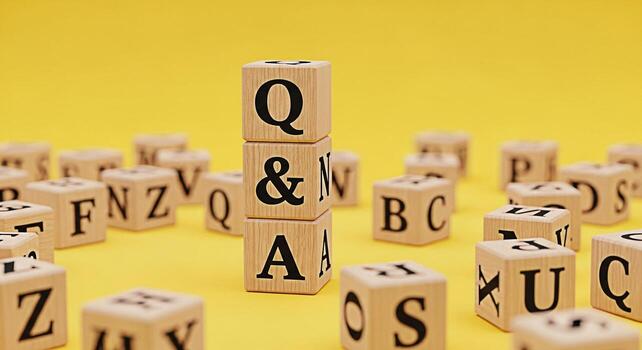 Stack of wooden blocks displaying QA on a bright yellow surface surrounded by alphabet blocks representing knowledge learning and the importance of asking questions in education and problemsolving photo