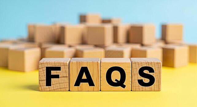 Wooden blocks spelling FAQs on a yellow surface against a blue background representing frequently asked questions customer support information access and a helpful and informative resource photo