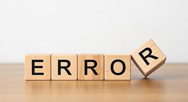 Wooden blocks spelling ERROR with one block falling on a bright surface symbolizing system failure mistake or problem in a clean minimalist environment conveying a sense of urgency and the need for tr photo