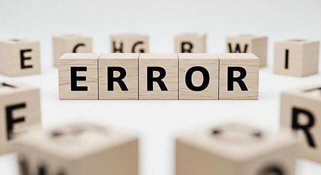 Wooden blocks spelling ERROR on a white surface surrounded by other lettered blocks symbolizing a system failure and the need for troubleshooting in a clean minimalist environment conveying a sense of photo