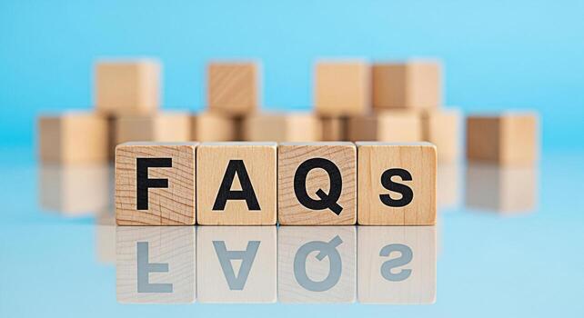 Wooden blocks displaying FAQs on a reflective surface against a soft blue background representing information access and customer support with a clean modern and informative aesthetic photo