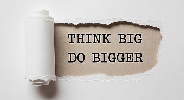 Torn paper revealing the motivational message Think Big Do Bigger in a minimalist setting symbolizing ambition growth and the power of positive thinking for business success and personal development photo