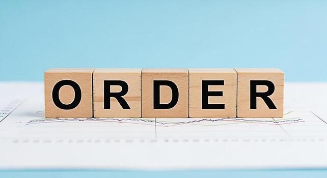 Wooden blocks spelling ORDER resting on a financial graph against a blue background representing organization structure and the importance of systematic processes in business and investment strategies photo