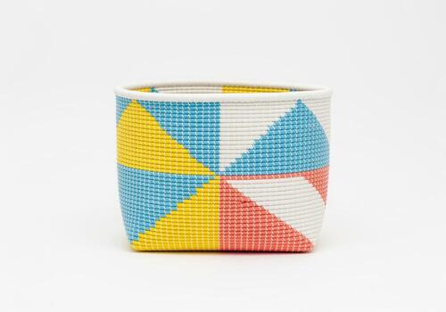 Handmade woven storage basket with colorful geometric triangle pattern isolated on white photo