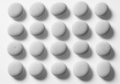 Close up of smooth gray volcanic pebbles perfectly arranged in a clean grid pattern photo