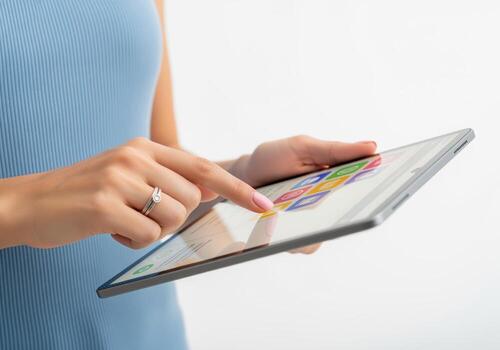 Female hands interacting with a touchscreen tablet device displaying colorful app icons photo