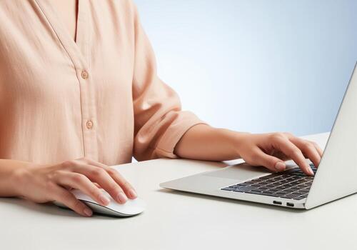 Woman hands typing on a laptop keyboard and clicking a wireless mouse for office work photo
