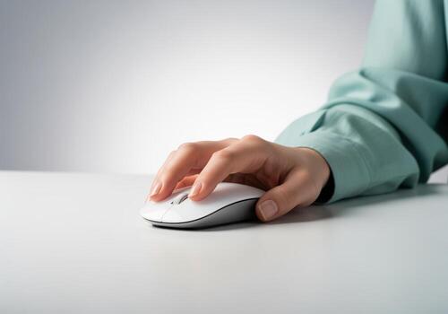 Woman hand interacting with a sleek white wireless computer mouse for office work. photo