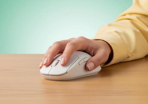 Woman hand using white wireless computer mouse on wooden desk surface photo