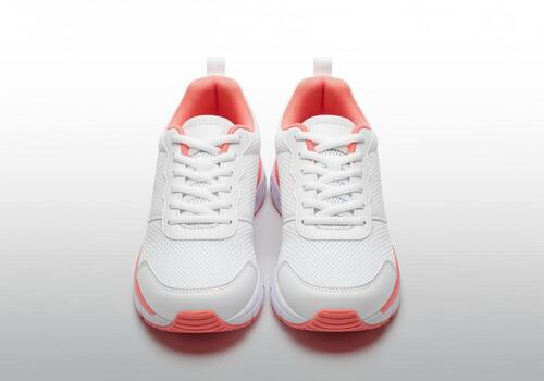 Front view of new white and salmon pink athletic running shoes on a bright studio surface photo