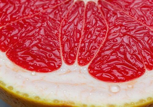 Refreshing macro view of wet, segmented pink grapefruit pulp and pith photo