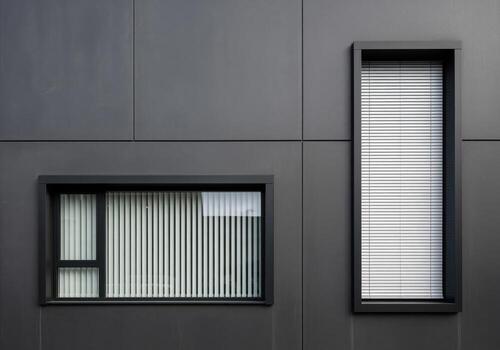 Minimalist dark gray architecture with contrasting geometric windows and blinds photo