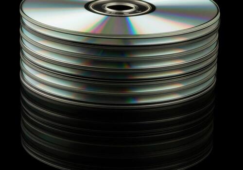 Close up of a tall stack of blank digital versatile discs reflecting rainbow light. photo
