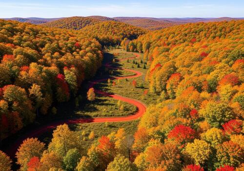 Spectacular autumn landscape with a winding trail through hills covered in colorful trees photo